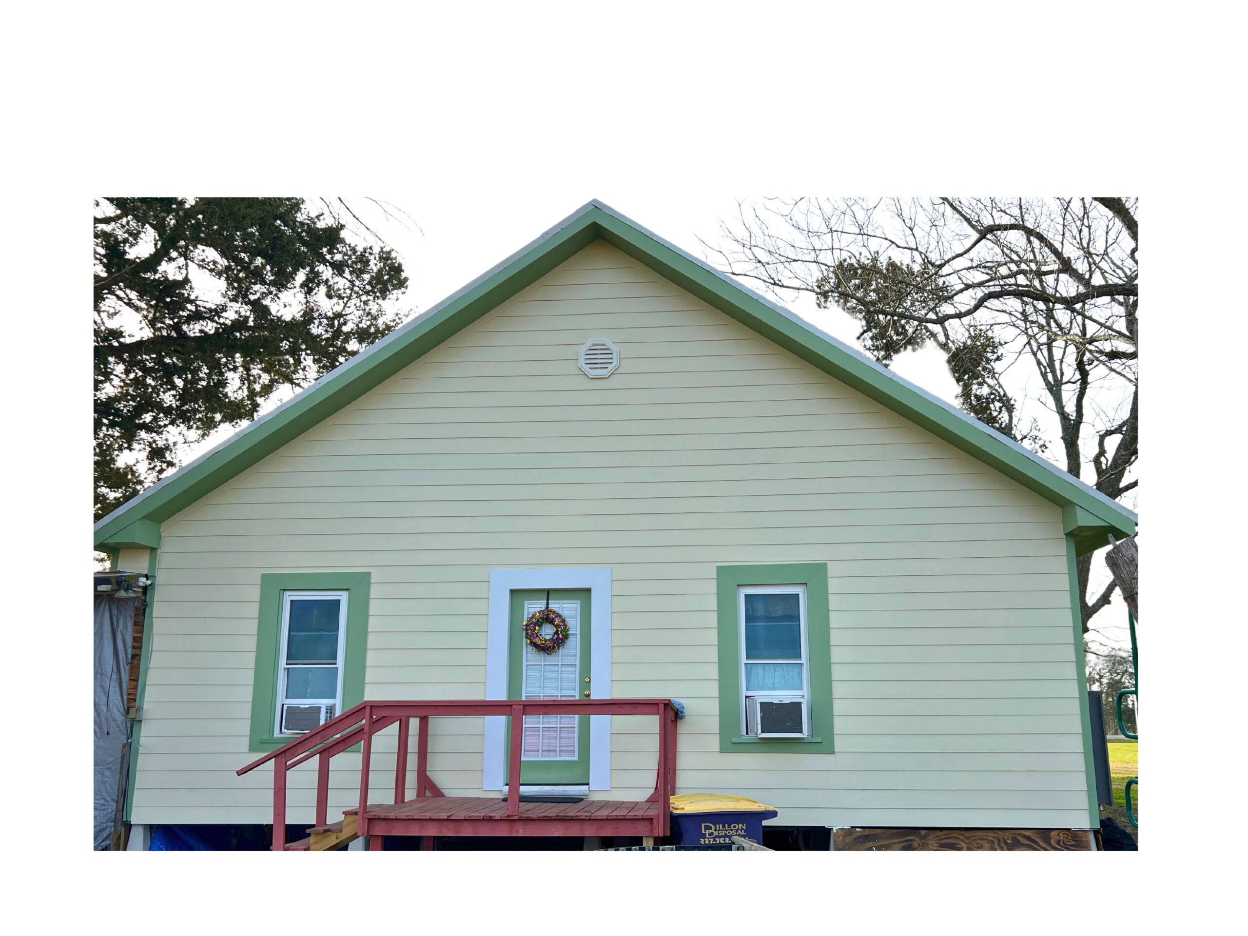A sage-green single-story house with new vinyl siding and green trim, completed by Deane Construction