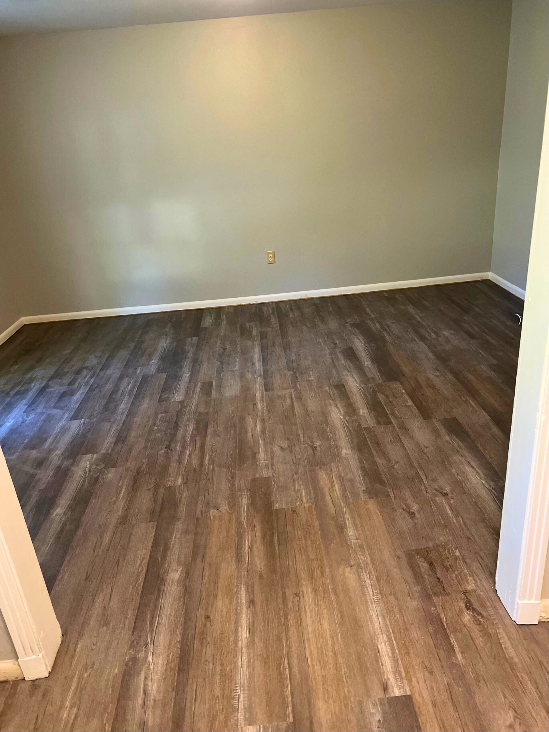 A room with new dark wood-look vinyl plank flooring, installed by Deane Construction